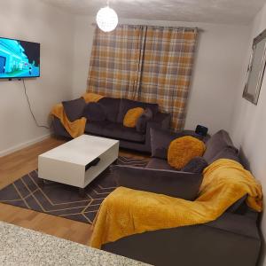 a living room with a couch and a tv at Lovely 2-Bed Apartment in Milton Keynes in Milton Keynes