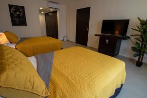 une chambre d'hôtel avec deux lits et une télévision à écran plat dans l'établissement Hotel Villas Segovia Playa del Carmen, à Playa del Carmen 64 autres photos