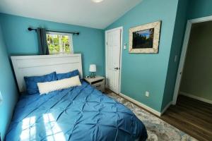 um quarto com paredes azuis e uma cama grande em NEW! Hurleyville Upstate NY - your Catskills getaway with hot tub, sauna and firepit! em Hurleyville