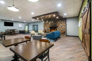 a waiting room with tables and a fireplace at Best Western Plymouth Inn-White Mountains in Campton