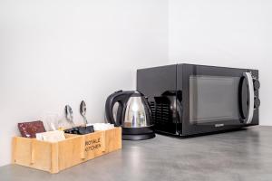 un forno a microonde, una macchinetta del caffè e una caffettiera di The Com Plex Motel a Whakatane