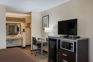 a hotel room with a flat screen tv and a desk at Best Western Nursanickel Hotel in Dalhart