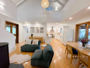 ein großes Wohnzimmer mit einem Tisch und einer Küche in der Unterkunft Mika · Cabin with fireplace, walk to the beach in Dunsborough