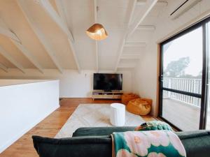 a living room with a couch and a tv at Mika · Cabin with fireplace, walk to the beach in Dunsborough