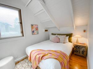 Un dormitorio con una gran cama blanca y una ventana en Mika · Cabin with fireplace, walk to the beach, en Dunsborough