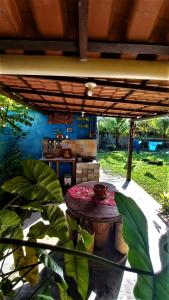 a patio with a table under a roof at Casa temporada na praia Joia do Atlântico - Ilhéus - Ba in Ilhéus