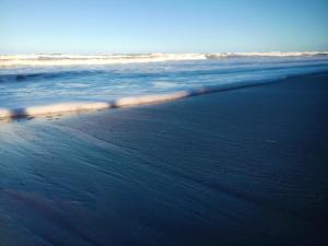a sandy beach with the ocean in the background at Casa temporada na praia Joia do Atlântico - Ilhéus - Ba in Ilhéus