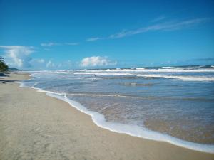 a sandy beach with waves on the ocean at Casa temporada na praia Joia do Atlântico - Ilhéus - Ba in Ilhéus