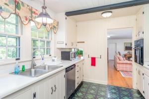 Sonshine Cottage في هيندرسونفيل: مطبخ بخزائن بيضاء ومغسلة
