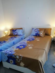 a bedroom with two beds with blue and brown sheets at Villa Marinos & Pool in Petrití