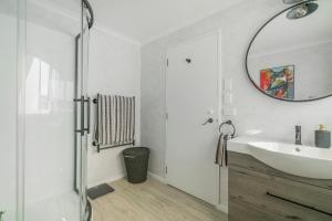 une salle de bain avec un lavabo et un miroir dans l'établissement Hosts on the Coast Harbour Lights, à Whitianga 30 autres photos