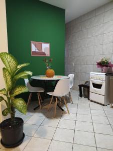 una cocina con mesa, sillas y una pared verde en Residencial Dete, en Florianópolis