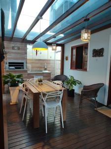 mesa de comedor y sillas en una terraza de madera en Residencial Dete, en Florianópolis
