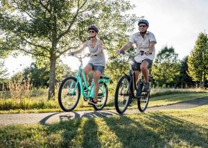 two people riding bikes down a road at River side suites in Belgrade