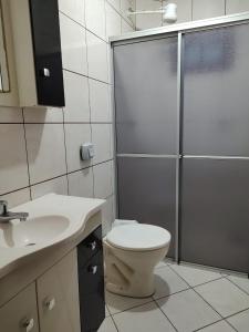 y baño con aseo, ducha y lavamanos. en Residencial Dete, en Florianópolis