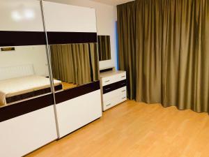 a bedroom with a bed and a dresser and a mirror at Spacious apartment on Main Street (City Center) in Kazanlŭk