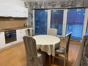 a kitchen with a table and chairs and windows at Spacious apartment on Main Street (City Center) in Kazanlŭk