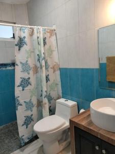 ein Badezimmer mit einem WC, einem Waschbecken und einem Duschvorhang in der Unterkunft Hotel boutique CVC in Acapulco