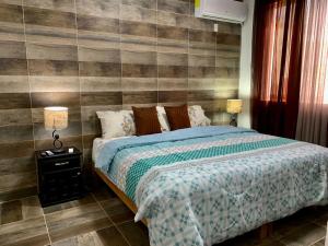 1 dormitorio con 1 cama y pared de madera en Hotel boutique CVC, en Acapulco