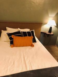 - un lit avec un oreiller orange dans l'établissement Cafeto Loft Lovely and private loft in Ruta de las Flores heart, à Juayúa