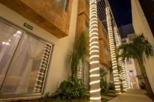 un poste con luces en el lateral de un edificio en Hotel Villas Segovia Suites Playa del Carmen en Playa del Carmen