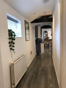 a hallway with a white radiator and a kitchen at Oddfellows Lodge in Stratford-upon-Avon