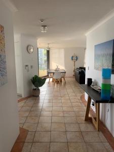 uma sala de estar com piso em azulejo e uma mesa em La Pacifique Apartments em Gold Coast