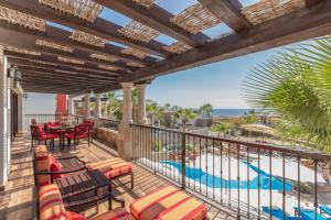 balcón con sillas y mesas y vistas a la playa en The Residences at Hacienda Encantada en Cabo San Lucas