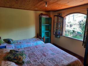 sypialnia z 2 łóżkami i oknem w obiekcie Casa da Marinda w mieście Visconde De Maua