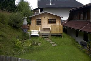 una pequeña casa con un banco en un patio en Ferienwohnungen Jagerhüttn, en Hochrindl