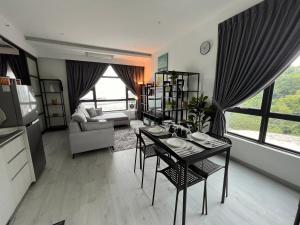 ein Wohnzimmer mit einem Tisch, Stühlen und einem Sofa in der Unterkunft Jesselton Quay Suite by Backyard in Kota Kinabalu