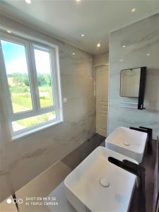baño con lavabo blanco y ventana en Maison des Pommiers - Bord de mer et campagne en Port-en-Bessin-Huppain