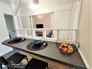une cuisine avec 2 bols de fruits sur un comptoir dans l'établissement Maison des Pommiers - Bord de mer et campagne, à Port-en-Bessin-Huppain