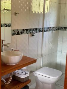 a bathroom with a sink and a toilet at Chalé Som da Sete Quedas Hidromassagem, Lareira e Vista para as Montanhas in Gonçalves +31 photos