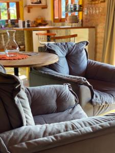 a wooden table with a couch and a table with a vase at Chalé Som da Sete Quedas Hidromassagem, Lareira e Vista para as Montanhas in Gonçalves