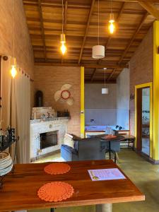 uma sala de estar com uma mesa e uma lareira em Chalé Som da 7 Quedas Apenas 1,8km do Centro de Gonçalves MG em Gonçalves