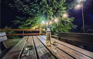 ein Holztisch mit zwei Gläsern Wein drauf in der Unterkunft 3 Bedroom Awesome Home In Suleczyno in Sulęczyno
