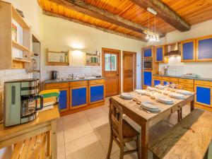 cocina con mesa de madera y armarios azules en Welcoming holiday home in Ohey with garden, en Ohey