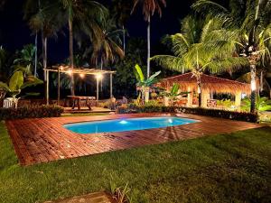 a backyard with a swimming pool at night at Kaçuá Milagres in São Miguel dos Milagres