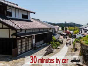 una calle en un pueblo asiático con texto a minutos en coche en 阿寺温泉 フォレスパ木曽あてら荘, en Okuwa