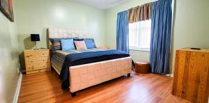 sypialnia z łóżkiem i oknem z niebieskimi zasłonami w obiekcie GREAT 2 bedroom Condo,FREE parking,easy commute. w mieście Irvington