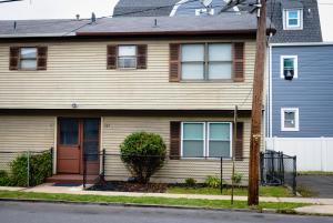 una casa con una porta marrone e una recinzione di GREAT 2 bedroom Condo,FREE parking,easy commute. a Irvington
