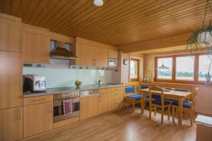 a kitchen with wooden cabinets and a table and a dining room at Ferienwohnung Lerch in Bregenz