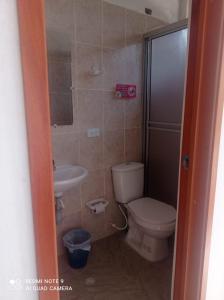 a bathroom with a toilet and a sink at Hotel Las Palmas de Puente Nacional in Puente Nacional