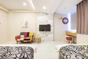 een kamer met 2 bedden en een tv aan de muur bij Flowers Blooming Homestay in Jian