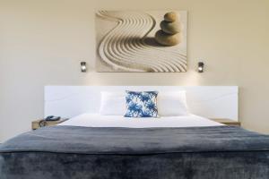 a bedroom with a bed and a painting on the wall at Pacific Hotel Cairns in Cairns