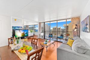 uma sala de estar com um sofá e uma mesa com frutas em Hawaii Dream Escape, Ocean Views & Free Parking em Honolulu