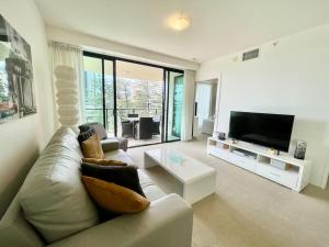 a living room with a couch and a flat screen tv at BB on the Park 502 in Gold Coast