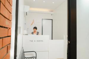 a woman sitting at a desk in front of a mirror at The A Hostel in Boracay