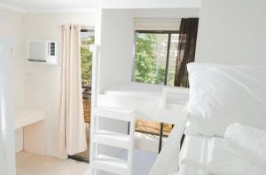 1 dormitorio con literas blancas y ventana en The A Hostel, en Boracay